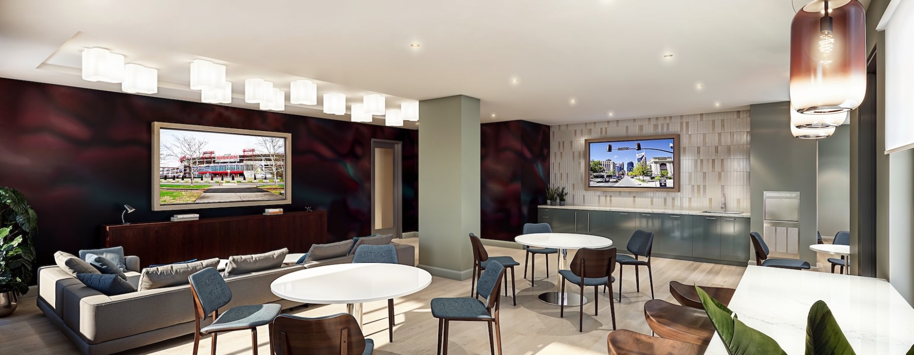Community lounge room with multiple seating options including a couch and chairs. Plus, two tv's for entertainment